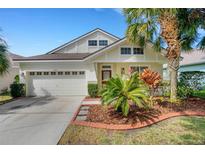 Charming one-story home featuring lush landscaping, a two-car garage, and a cozy front porch at 6019 Gannetdale Dr, Lithia, FL 33547