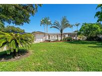 Charming single story home with a well-manicured lawn and several palm trees in the front yard at 1163 60Th S Ave, St Petersburg, FL 33705