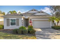 Charming single-story home with a well-manicured lawn, shuttered windows, and attached two-car garage at 11794 Forest Park Cir, Bradenton, FL 34211