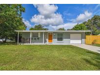 Charming single-story home with a well-manicured lawn, a covered front porch, and an attached garage at 1260 S Hillcrest Ave, Clearwater, FL 33756