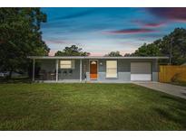 Charming single-story home featuring a well-maintained lawn and bright orange front door at 1260 S Hillcrest Ave, Clearwater, FL 33756