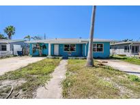 Charming one-story home with a bright blue exterior and a well-maintained front yard at 14040 Miramar Ave, Madeira Beach, FL 33708
