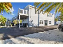 Two-story home featuring siding, a second story deck, and an asphalt and stone driveway at 14924 Old Dixie Hwy, Hudson, FL 34667