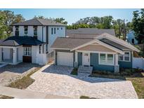 Charming blue craftsman style home featuring a brick driveway, attached garage, and manicured landscaping at 1510 49Th N St, St Petersburg, FL 33710
