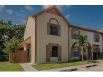 Charming townhouse with two stories, reserved parking, and a small palm tree in the front yard at 1701 Brigadoon Dr, Clearwater, FL 33759