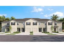 New townhomes with attached garages, covered entryways, and a beautifully landscaped lawn at 17511 Spanish Oak Loop, Land O Lakes, FL 34638