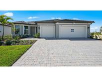 Beautiful single-story home with a paved driveway, two-car garage, and well-maintained landscaping at 1895 Ridgemore St, North Port, FL 34289