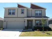 Charming two-story home with a front yard, attached garage and covered front porch at 31888 Treasure Dock Isle, Wesley Chapel, FL 33545