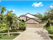 Stunning two-story home featuring stone accents and a spacious three-car garage at 5324 Moon Shell Dr, Apollo Beach, FL 33572