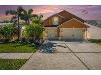 Charming two-story home with a three-car garage, lush landscaping, and a well-maintained driveway at 7116 Colonial Lake Dr, Riverview, FL 33578