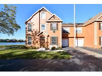 Charming two-story townhome featuring a well-maintained lawn and a serene lake view at 9008 Lake Chase Island Way, Tampa, FL 33626