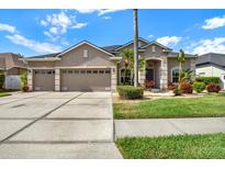 Charming home featuring a three car garage, well-manicured lawn, and inviting landscaping at 22647 Eagles Watch Dr, Land O Lakes, FL 34639