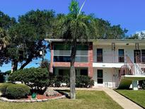 Charming condo building with red brick accents, well-maintained lawn, and lush landscaping at 2348 Shelley St # 8, Clearwater, FL 33765