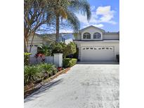 Charming two-story home with a well-manicured lawn, lush landscaping, and a two-car garage at 2523 Northfield Ln, Clearwater, FL 33761