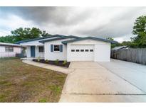 Charming single-story home boasts a freshly painted exterior, an attached garage, and a well-maintained front yard at 2610 E Yukon St, Tampa, FL 33604