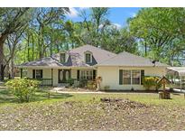 Charming single-story home with a well-maintained lawn and mature trees offering shade and curb appeal at 26290 Hayman Rd, Brooksville, FL 34602