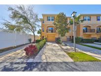 Charming townhouse with tan exterior, balcony, driveway, one car garage, and lush landscaping at 5036 Sand Castle Dr, New Port Richey, FL 34652