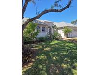 Charming single-story home featuring a well-maintained lawn and lush landscaping at 5261 Camberlea Ave, Zephyrhills, FL 33541