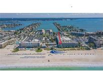 Stunning aerial view of the beachfront resort with a large water slide on the beach and beautiful Gulf Coast waters at 5500 Gulf Blvd # 4226, St Pete Beach, FL 33706