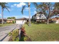 Inviting two-story home with lush lawn, mature trees, and a welcoming mailbox at 5938 Oakhurst Dr, Seminole, FL 33772
