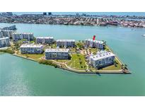 Stunning aerial view of waterfront condo complex surrounded by lush landscaping and picturesque water views at 8040 Sailboat Key S Blvd # 402, St Pete Beach, FL 33707