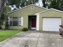 Charming one-story home with an attached garage and a well-manicured front yard at 1706 E Fern St, Tampa, FL 33610