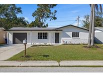 Charming single-story home with a well-maintained lawn, front yard, and a one car garage at 3249 Masonville Loop, Holiday, FL 34691