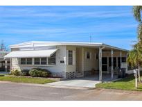 Charming single-story home featuring a covered carport, awning, and landscaped yard, creating a welcoming and comfortable curb appeal at 369 Cobia Way, Oldsmar, FL 34677