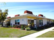 Charming condo featuring updated exterior with a well-manicured lawn and cozy front porch at 4338 Tahitian Gardens Cir # H, Holiday, FL 34691