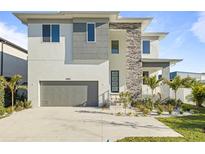 Modern two-story home featuring a gray garage door, stone accents, and well-manicured landscaping at 4405 W Euclid Ave, Tampa, FL 33629