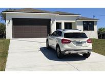 Charming single-story home with a two-car garage and a white car parked in the driveway, enhancing its curb appeal at 5166 Deltona Blvd, Spring Hill, FL 34606