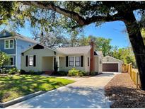 Charming single-story home with a well-maintained lawn, brick chimney, and detached garage at 6710 N 13Th St, Tampa, FL 33604