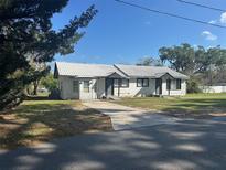 Charming home featuring a metal roof, white exterior and a concrete driveway on a sunny day at 1006 W Morse St, Plant City, FL 33563