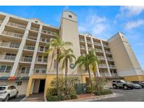 Modern condo building with lush landscaping and covered parking at 1200 Country Club Drive Dr # 3303, Largo, FL 33771