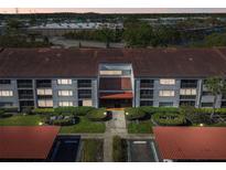 This aerial view showcases the well-maintained building with lush landscaping and ample parking at 2595 Countryside Blvd # 8-305, Clearwater, FL 33761