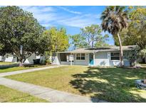 Charming single-story home with a well-manicured lawn and mature trees at 4421 W Iowa Ave, Tampa, FL 33616