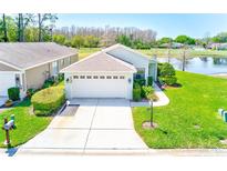 Charming home with lush green lawn, well-manicured landscaping, and attached two car garage at 9426 Green Needle Dr, New Port Richey, FL 34655