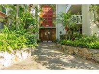 Elegant building entrance with lush landscaping and decorative doors at 1012 Pearce Dr # 105, Clearwater, FL 33764