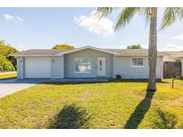 Charming single-story home with a well-maintained lawn and an attached garage at 10900 Oakdale Ave, Port Richey, FL 34668