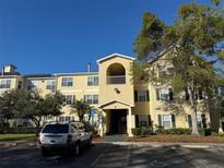 Attractive condo building with yellow siding, green shutters, and manicured landscaping in a well-maintained community at 18575 Bridle Club Dr # 18575, Tampa, FL 33647