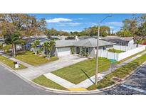 Charming single-story home featuring a well-manicured lawn and a white picket fence enhancing curb appeal at 1947 Citrus Hill Ln, Palm Harbor, FL 34683