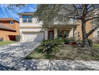 Charming two-story home featuring a well-maintained lawn, inviting front porch, and attached two-car garage at 20220 Autumn Fern Ave, Tampa, FL 33647