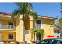Inviting two-story condo featuring white balconies and tropical landscaping creating a serene outdoor living space at 21011 Picasso Ct # 101, Land O Lakes, FL 34637