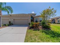 Charming single-story home features a well-manicured lawn, two-car garage, and decorative landscaping at 2234 Nottingham Greens Dr # 2234, Sun City Center, FL 33573