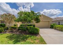 Well-maintained single-story home with lush landscaping, a manicured lawn, and a spacious two-car garage at 2286 Sifield Greens Way # 2286, Sun City Center, FL 33573