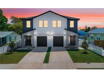 Modern townhome featuring a black roof, gray accents, and individual driveways with manicured lawn at 2608 W Saint Joseph St # 2, Tampa, FL 33607