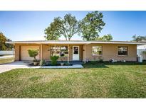 Charming single-story home with covered porch, manicured lawn and beautiful landscaping at 2707 Morningside Dr, Clearwater, FL 33759