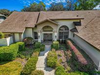 Charming home featuring a meticulously landscaped front yard with a symmetrical walkway leading to the front door at 2806 Forest Club Dr, Plant City, FL 33566