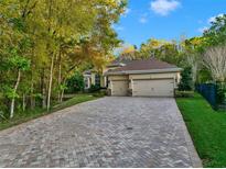 Beautiful single-story home boasting a three-car garage and a long brick paver driveway at 3198 Thatcher Ln, Tarpon Springs, FL 34688