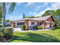 Charming single-story home with well-maintained landscaping and a screened two-car garage at 3212 Mcmath Dr, Palm Harbor, FL 34684